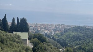 A coastal cityscape with dense urban buildings, a visible coastline, and surrounding greenery. - Pretty Studio Flat Moglio Alassio (Moglio)