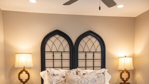 A bedroom with a bed, two bedside tables with lamps, a ceiling fan, and a bench. - The Bee, Cozy 1BR Studio by Velvet Ditch Villas (Oxford)