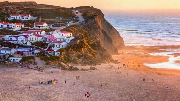 A coastal town with buildings on a cliff overlooking the sea. - Sun, Sand & Surf Apt in Aljezur by Lisbeyond (Aljezur)