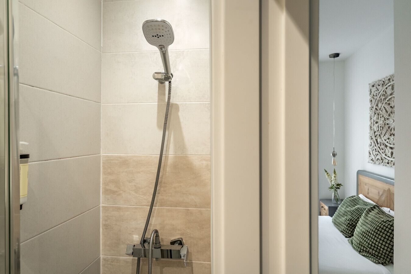 A shower with a handheld showerhead, a handheld shower attachment, and a wall-mounted control valve.