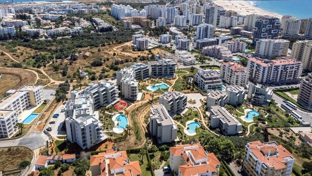 A coastal residential area with high-rise buildings, swimming pools, and a beach in the background. - Oasis Mar Beach Apartment by Lisbeyond (Portimão)