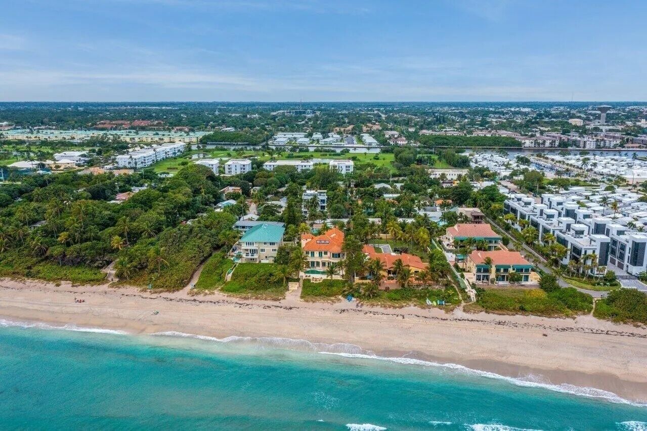 Ein Luftbild eines Küstenresorts mit Strandvillen, einer Marina und üppiger Vegetation.