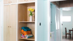 Ein Zimmer mit einem Holzschrank, einer Vase mit gelben Blumen und einem Essbereich mit Tisch und Stühlen.
