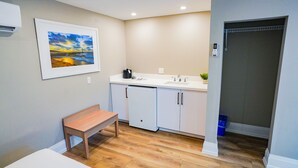 A compact kitchen with a bench, a sink, and a small potted plant.