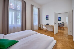 Een hotelkamer met twee bedden, een bureau en een stoel.