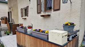 En träaltan med en inbyggd grill och ett vitt kylskåp.