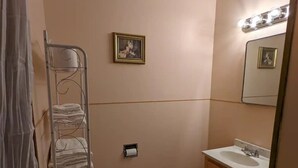 Une salle de bain équipée de toilettes, d’un lavabo et d’un porte-serviettes.