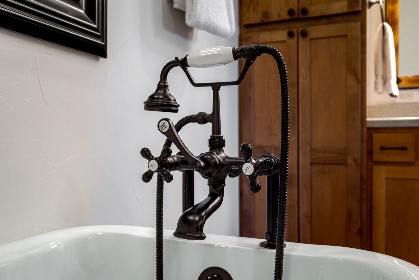 Een badkuip in vintage stijl, met een messing kraan en een handdouche.