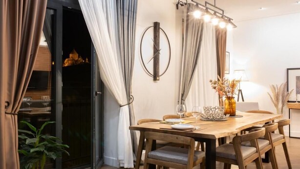 A dining area with a wooden table, chairs, and a vase with flowers. - Marrone Hotel Tsaghkadzor (Tsaghkadzor)