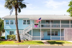 A two-story building with a balcony, a flag, and a sign indicating a restaurant.