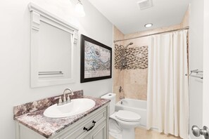 A bathroom with a sink, toilet, and bathtub.