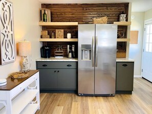 A modern kitchen with a stainless steel refrigerator, wooden shelves, and a coffee maker. - Cozy 3BR on 1 acre ~ Pet friendly ~ Great Location (Elizabethtown)