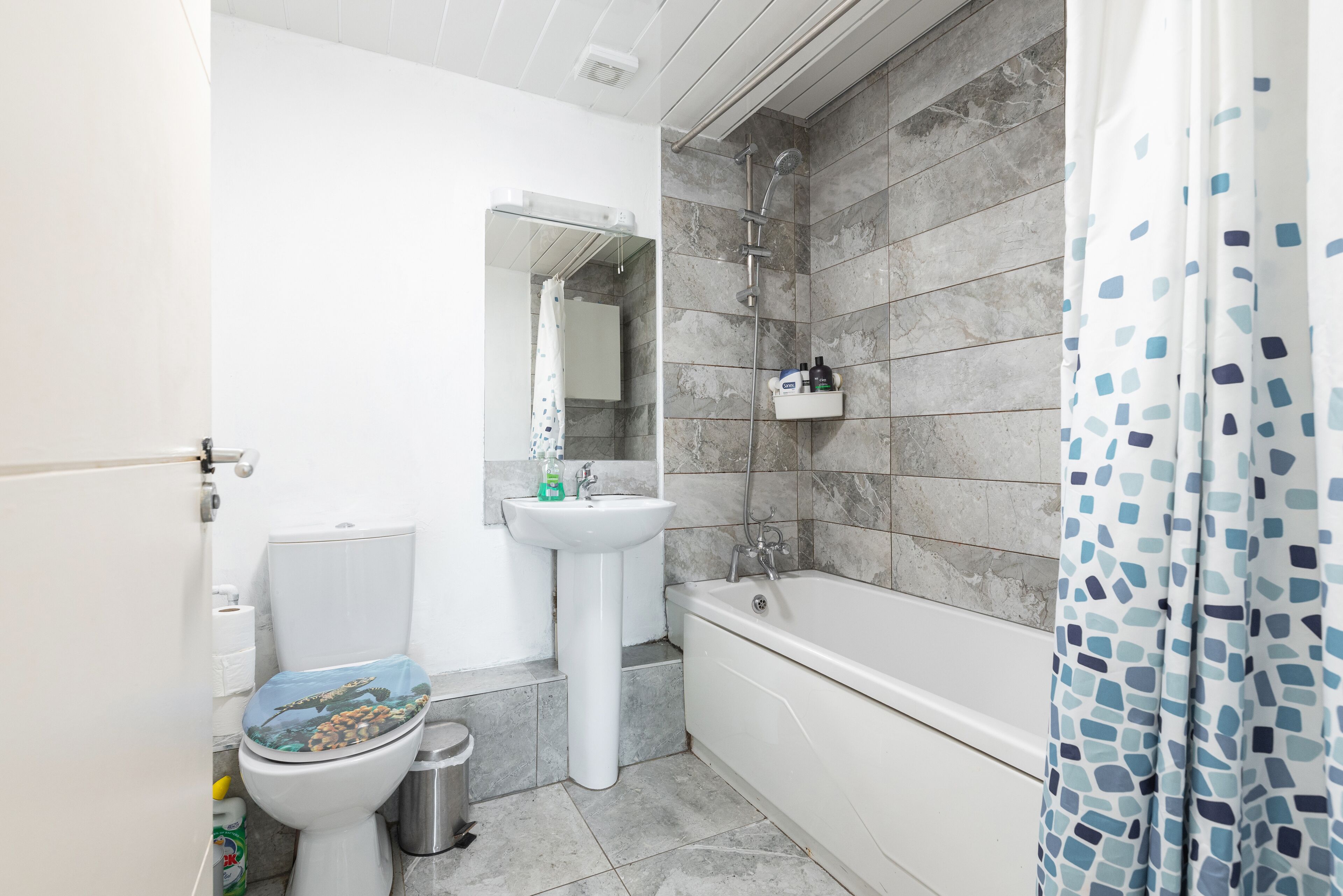 Een badkamer met toilet, wastafel en bad.