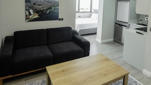 A modern apartment with a living area, a dining table, a kitchen, and a bedroom. - Grand Family Home (Trabzon)