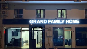 The exterior of a hotel named "Grand Family Home" with a modern design, featuring a prominent sign and a series of windows. - Grand Family Home (Trabzon)