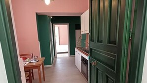 A narrow hallway with a dining area on one side and a kitchen on the other. - A cozy refuge in the sky (tramonti)