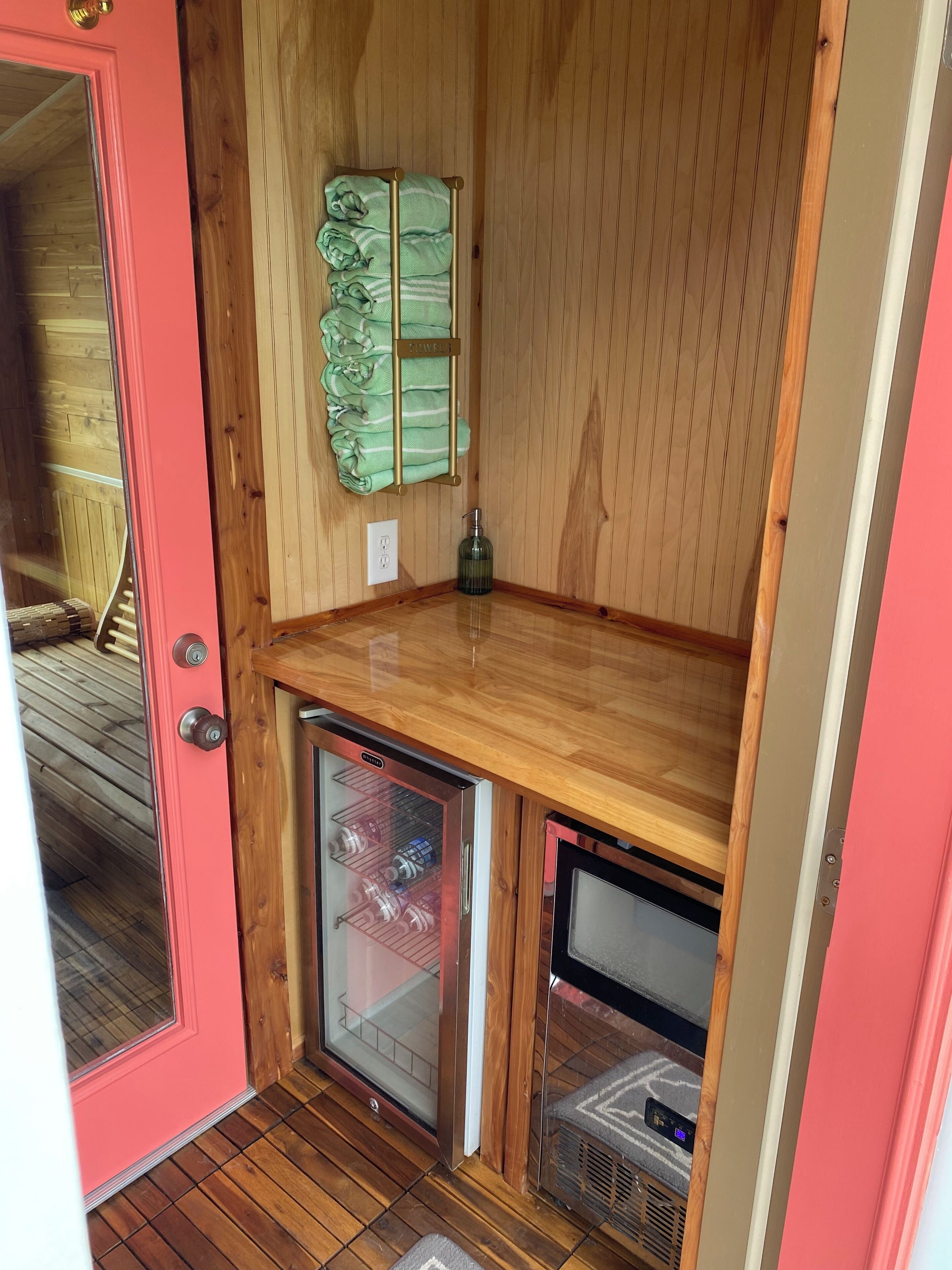 A compact kitchen with a wooden countertop, a built-in mini-fridge, and a towel rack.