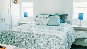 A bedroom with a bed, bedside tables, and a window. - Waterfront with spectacular views, peaceful and private duplex, fishermens dream (Beaufort NC)