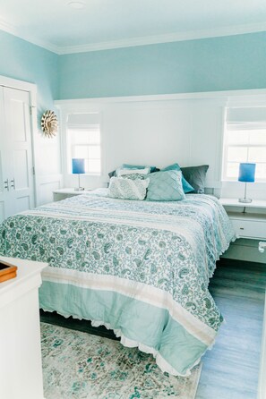 A bedroom with a bed, bedside tables, and a window. - Waterfront with spectacular views, peaceful and private duplex, fishermens dream (Beaufort NC)