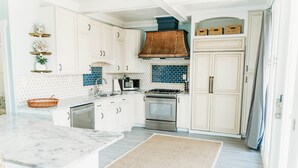 A kitchen with white cabinets, a stainless steel stove, and a microwave. - Waterfront with spectacular views, peaceful and private duplex, fishermens dream (Beaufort NC)
