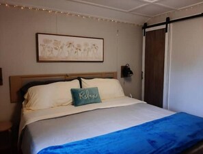 Cozy retreat with a single bed, framed artwork, and a nightstand with a lamp.