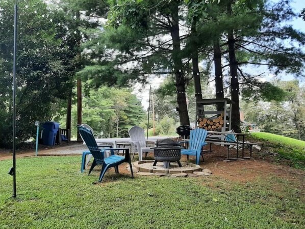 Relax in a natural setting with a round table and comfortable seating, perfect for outdoor dining and cooking.
