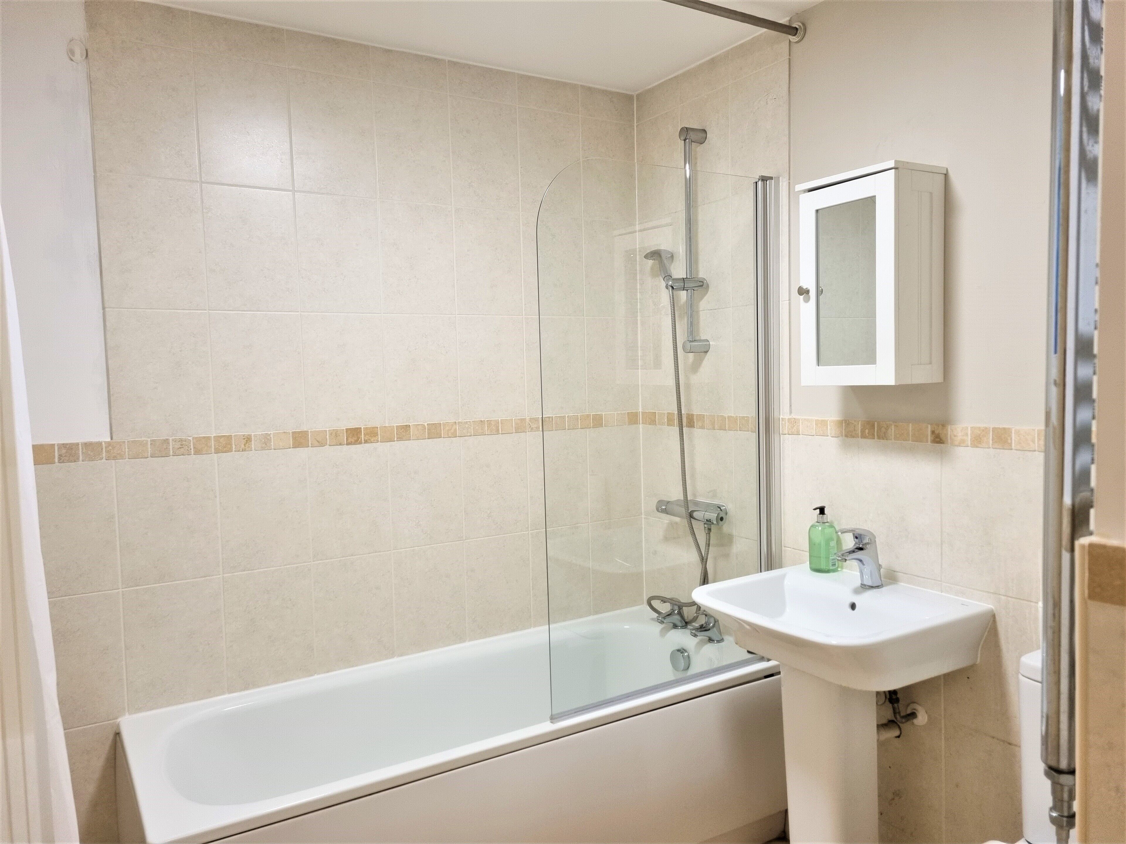 Un baño con bañera, ducha y lavabo.