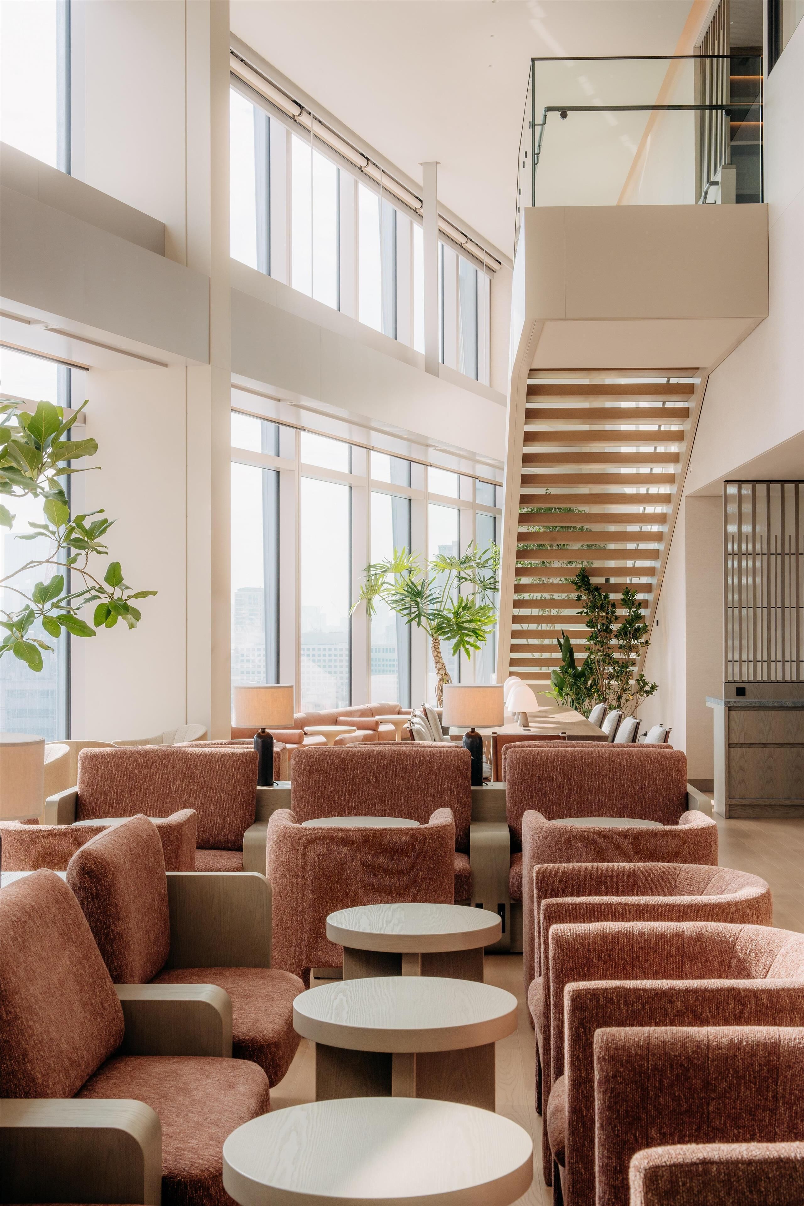 A modern interior with seating, tables, and a staircase.
