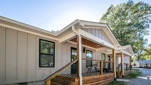 A two-story house with a covered porch, a staircase, and a small outdoor seating area. - The Paige, Cozy 1BR Studio by Velvet Ditch Villas (Oxford)