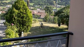Balc ón con vistas a un paisaje rural, que incluye casas y vegetación.
