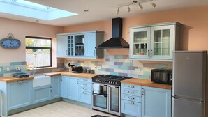 A modern kitchen with light blue cabinets, a stainless steel stove, and a built-in oven. - Large 5 Bedroom House Terrace Parking (Swindon)