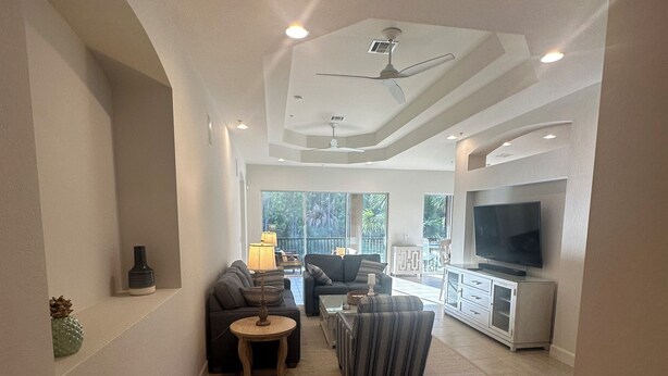 A spacious living room with a large TV, comfortable seating, and a view of the outdoors. - Gorgeous 2nd Floor Unit in The Quarry, Minutes to downtown Naples and Mercato. (Naples)