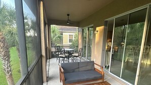 A covered patio with a sofa, chairs, and a table. - Gorgeous 2nd Floor Unit in The Quarry, Minutes to downtown Naples and Mercato. (Naples)