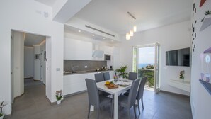 Een moderne keuken met een eethoek, grote ramen en uitzicht op het landschap.