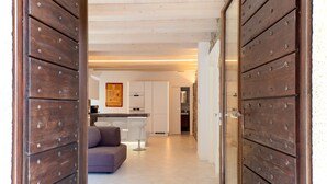A modern interior with wooden doors, a kitchen area, and a seating area with a sofa and chairs. - Ca' Luigia boutique apartment in Montorfano (Mergozzo)