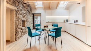 Una cocina moderna con pared de piedra, vigas de madera en el techo y un tragaluz.