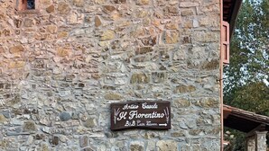 Een stenen gebouw met een bord waarop staat: Antico Casale Il Fiorentino B&B Casa Lontane.