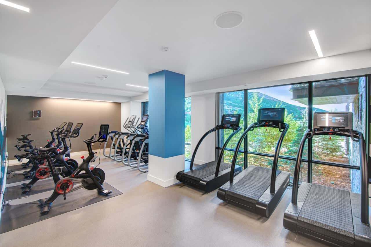 Una palestra con cyclette, tapis roulant e attrezzature per esercizi.