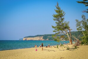 A beach with clear skies, calm sea, and people relaxing.