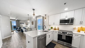 A modern kitchen with white cabinets, stainless steel appliances, and a central island. - Million dollar views, sleeps 10! Beachfront corner unit @ Grand Panama Resort! (Panama City Beach)