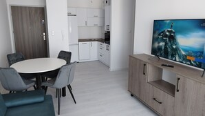 A modern kitchen with white cabinets, a built-in oven, and a sink. - Family Homes - Apartament Sea View (Wladyslawowo)
