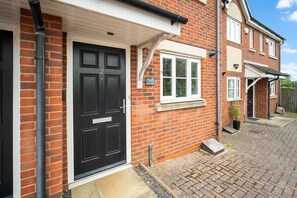 A brick house with a black front door, a small window, and a number '2' sign. - 2 Bedroom House - Parking - Garden - Oldbury (Oldbury)