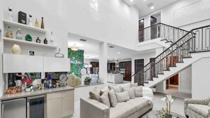 A spacious living area with a neutral color scheme, a sofa, a coffee table, and a staircase. - Tiki Las Olas, Fort Lauderdale (Fort Lauderdale)