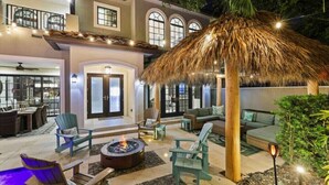 An outdoor patio with seating, a fire pit, and a thatched roof structure. - Tiki Las Olas, Fort Lauderdale (Fort Lauderdale)