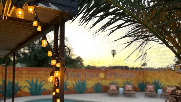 A pool area with a mural, lounge chairs, and string lights. - ༄The Agave Ranch༄ FREE Pool Heating & Arcade Room! (Phoenix)