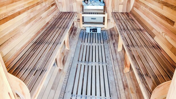 Un sauna avec des murs et des bancs en bois.