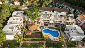 An aerial view of a resort with multiple buildings, a swimming pool, and lush greenery. - EndlessSummer Beach Escape (Playas Del Coco)