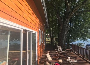 A wooden deck with outdoor seating and a view of the water.