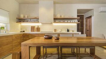 Une cuisine moderne avec des meubles en bois, un îlot central et des étagères intégrées au-dessus du plan de travail.