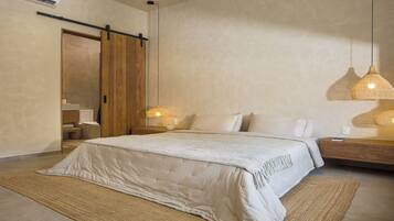 A modern bedroom with a large bed, a wooden wardrobe, a bedside table with a lamp, and a wall-mounted air conditioner.